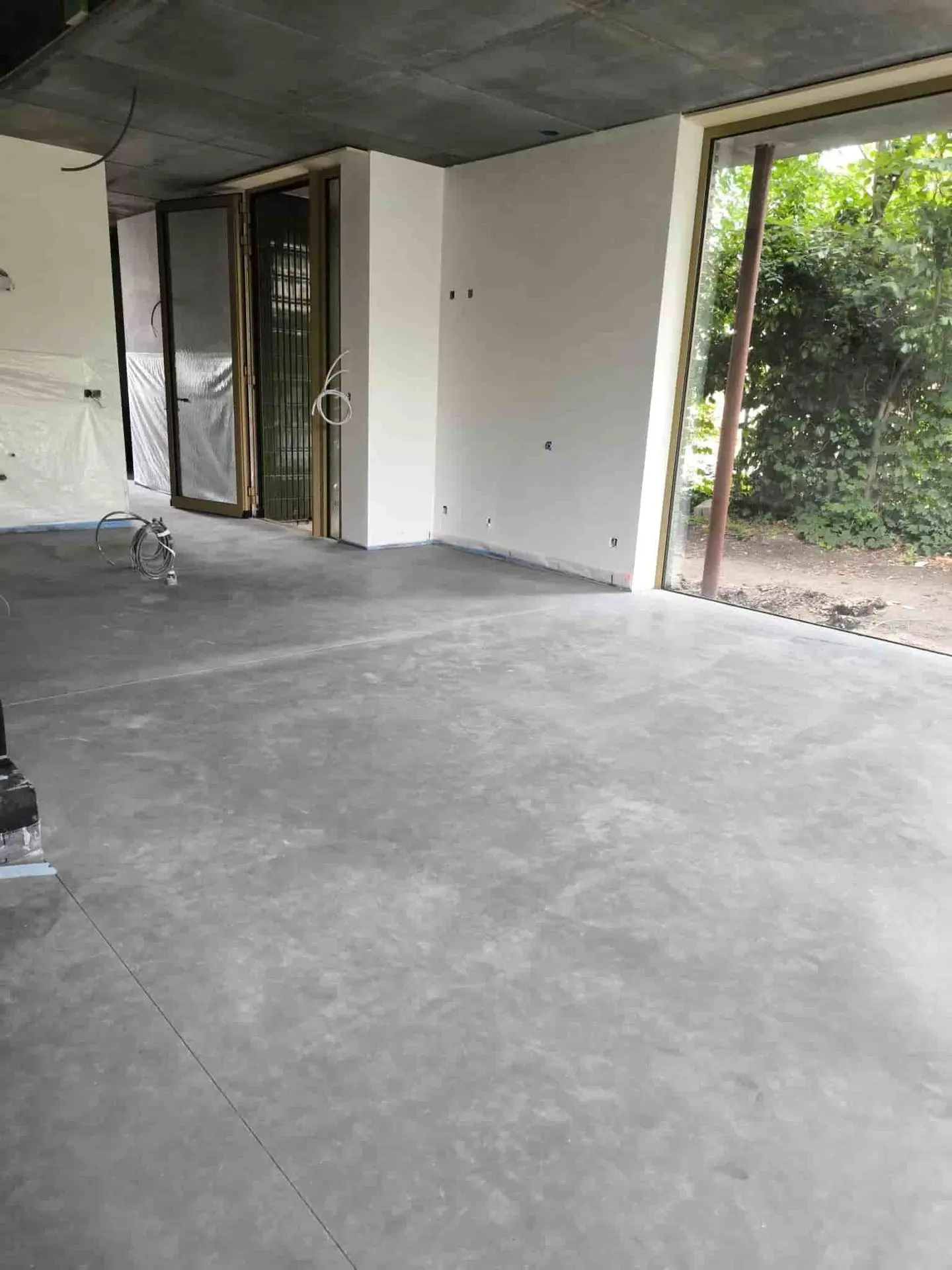 Gepolierde betonvloer bij grote ramen in een woning in Leopoldsburg