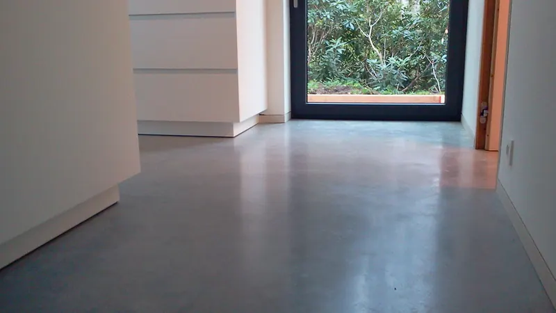 Natuurlijke kleurnuances van een gepolierde betonvloer bij een raam