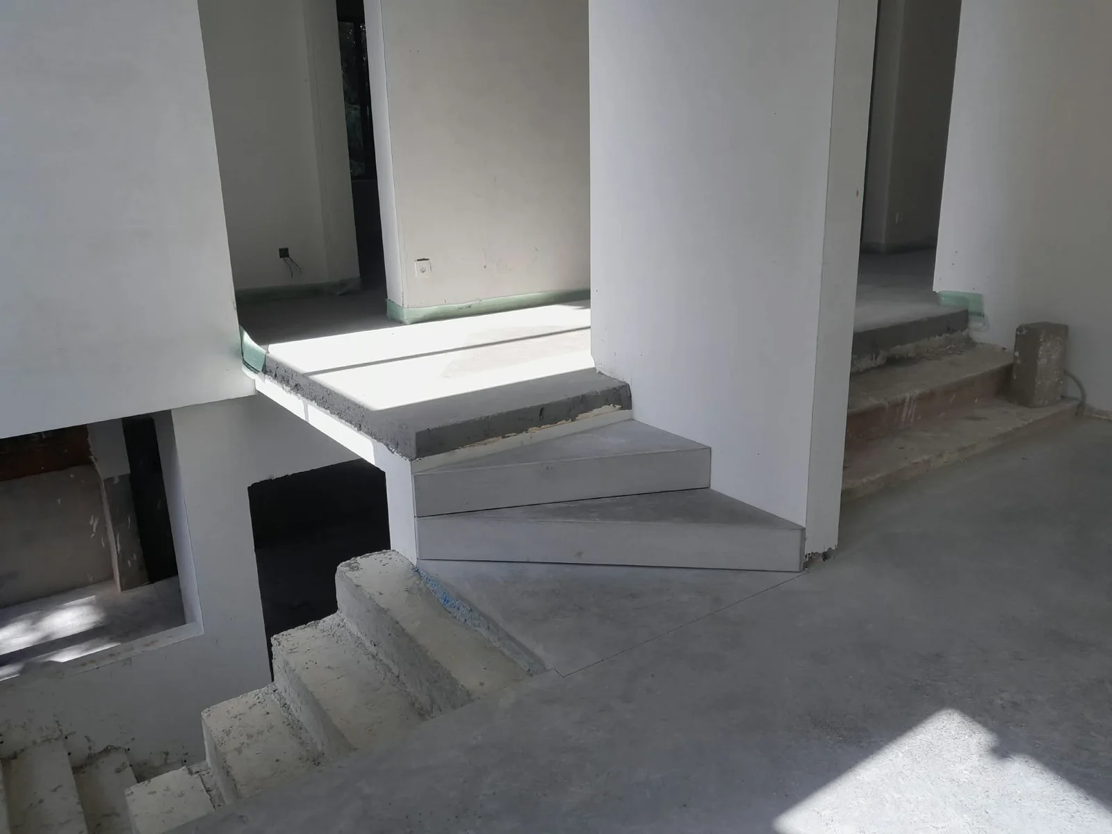 Gepolierde betonnen traptreden rond de centrale wand in een woning in Genk