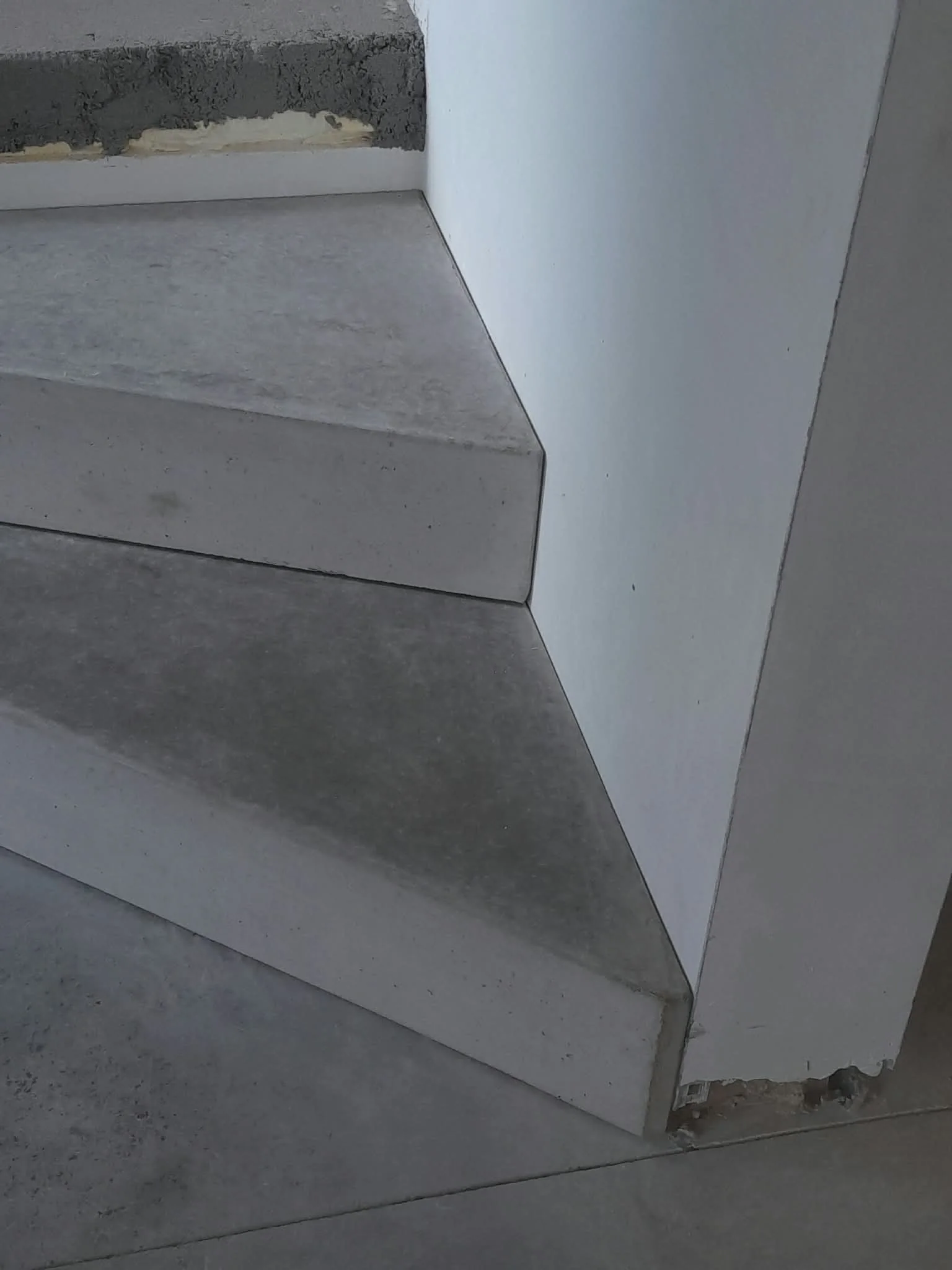 Detail van de schuine gepolierde betonnen traptreden in Genk