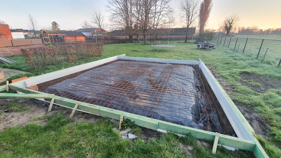 Houten bekisting met schoren en wapeningsnetten vóór het storten van een betonplaat