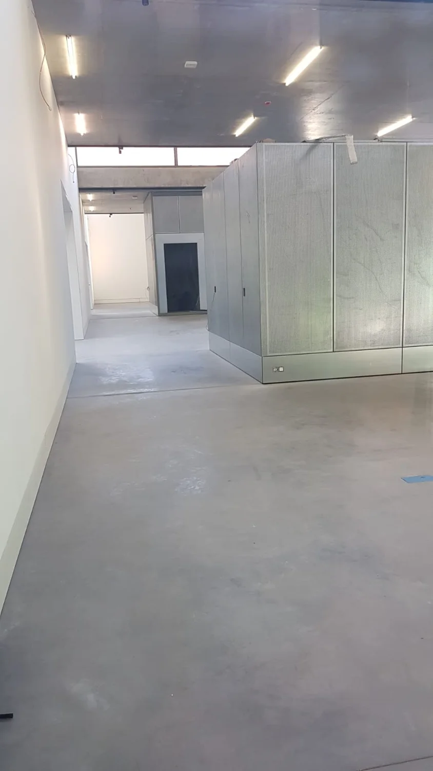 Afgewerkte betonvloer in het collectiepaviljoen tijdens de werfperiode