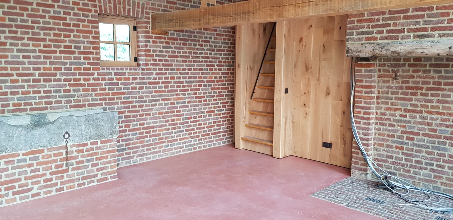 Warme betonvloer bij een houten deur en bestaande bakstenen muren