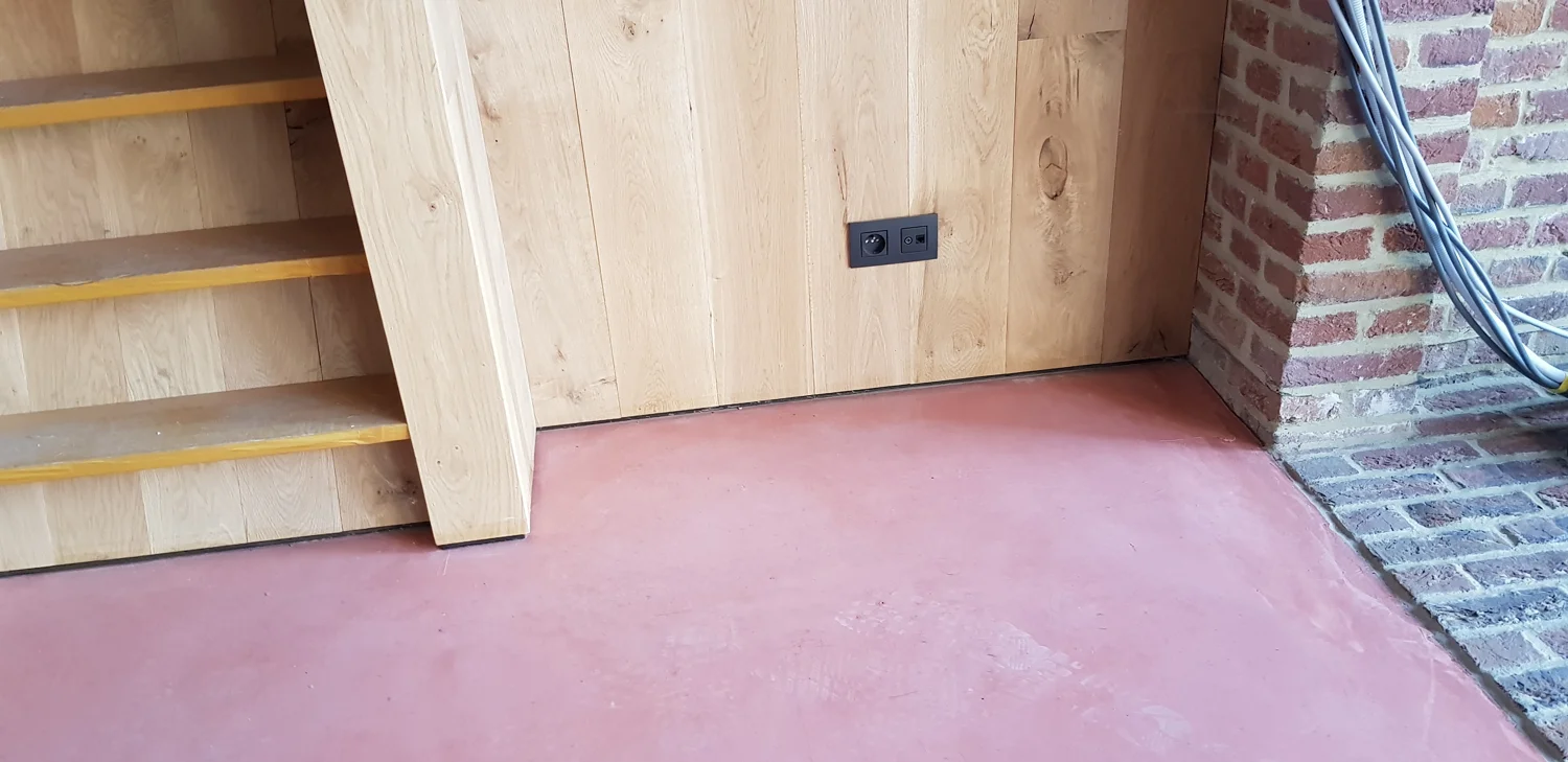 Aansluiting van de terracottakleurige vloer bij de houten trap