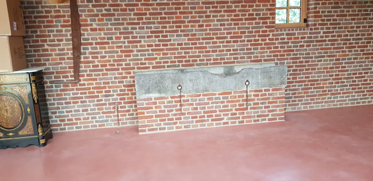 Terracottakleurige betonvloer bij de bestaande bakstenen muren