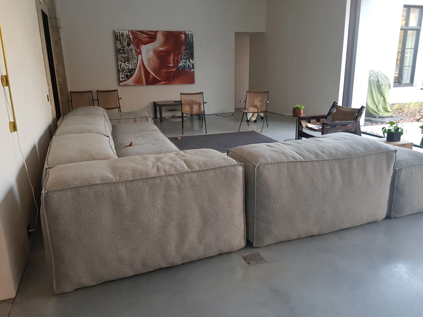 Grijze betonvloer onder de zitbank in een ingerichte woning in Leuven