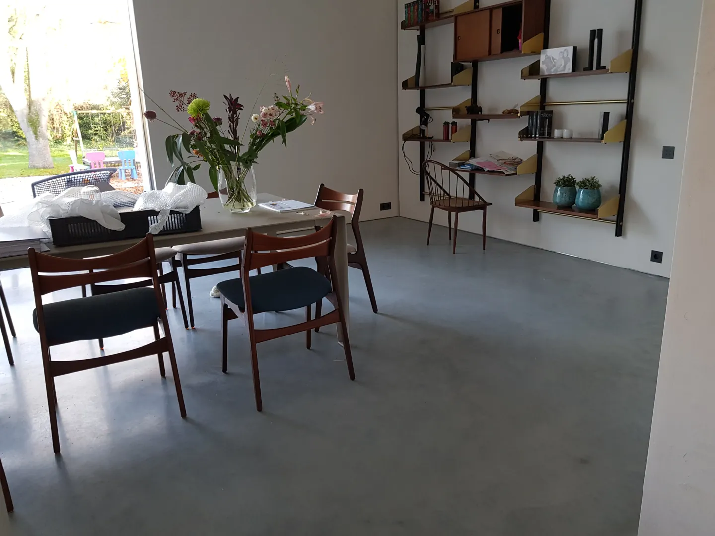 Eettafel en tuinzicht boven de grijze betonvloer