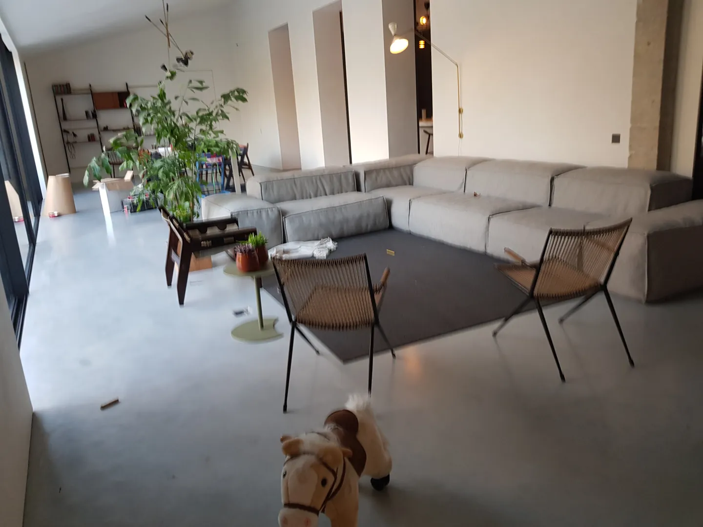 Betonvloer met zitbank en fauteuils in de woonkamer