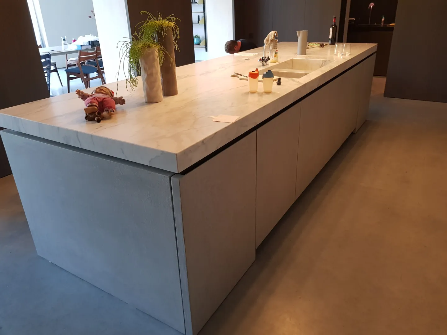Keukeneiland met houten kasten en grijze vloer