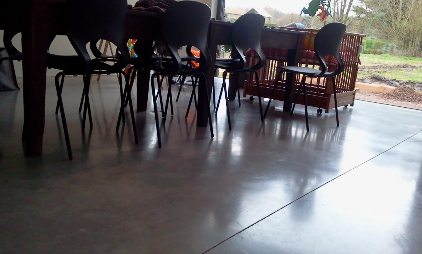 Eettafel en stoelen boven de gepolierde betonvloer