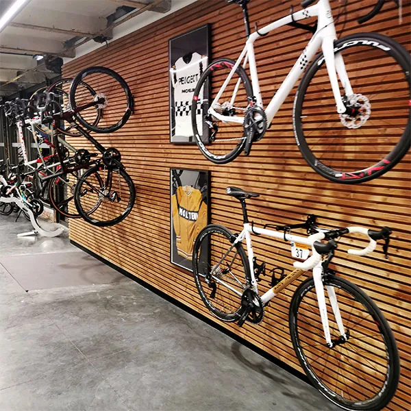 Fietspresentatie op houten wand naast de grijze winkelvloer