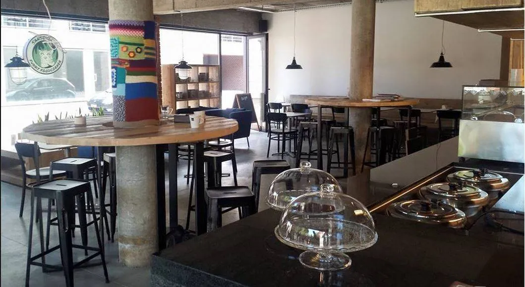 Ingericht horeca-interieur met grijze betonvloer en tafels