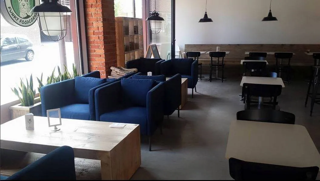 Zithoek met blauwe fauteuils boven de betonvloer