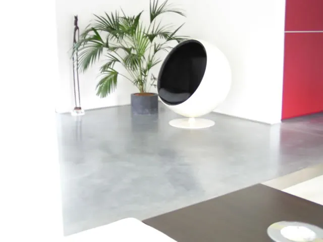 Witte ronde designzetel op een cementkleurige betonvloer in Wilrijk