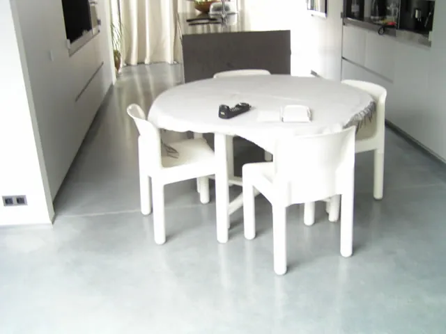 Eethoek met witte tafel en grijze gepolierde betonvloer