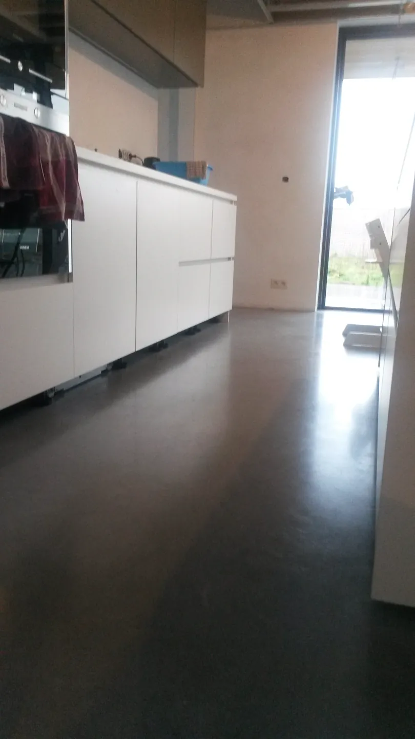 Witte keuken boven een donkere gepolierde betonvloer