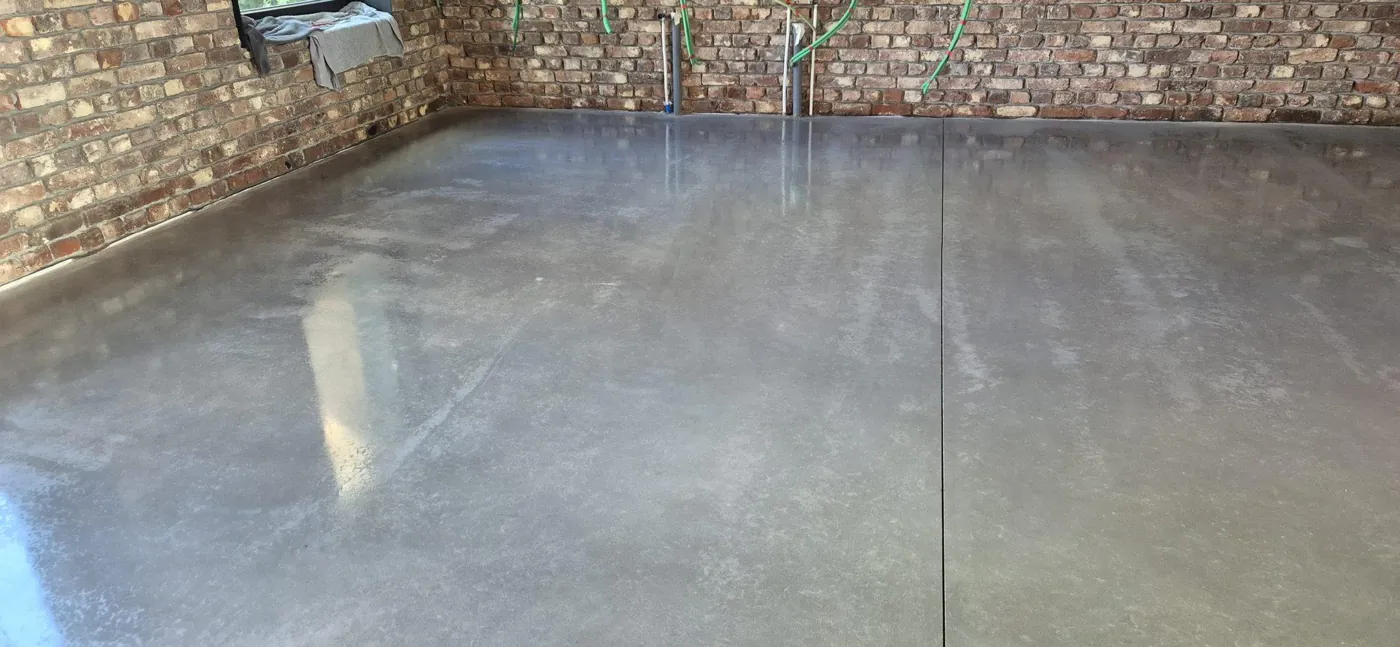 Betonvloer in Glabbeek na een beschermingsbehandeling. Deze latere bescherming heeft een ander doel dan curing van vers beton.