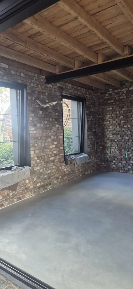 Afgewerkt woonbeton in Glabbeek als voorbeeld van het eindbeeld. De verwarmingsopbouw van dit project is hier niet zichtbaar.