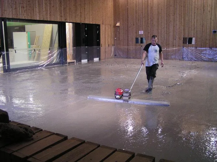 De betonvloer voor JIM TV wordt met een brede afwerkspaan vlak gemaakt