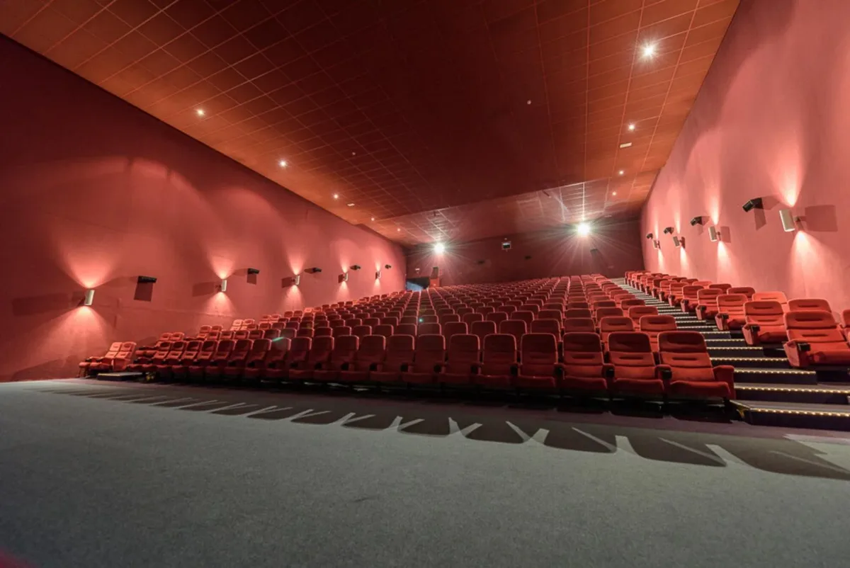 Bioscoopzaal als sfeerbeeld bij het project in Winterslag. De betonnen ondergrond van de trappen zit onder de vloerbekleding.