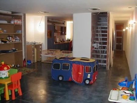 Overzicht van de kinderopvang met blauwzwarte betonvloer