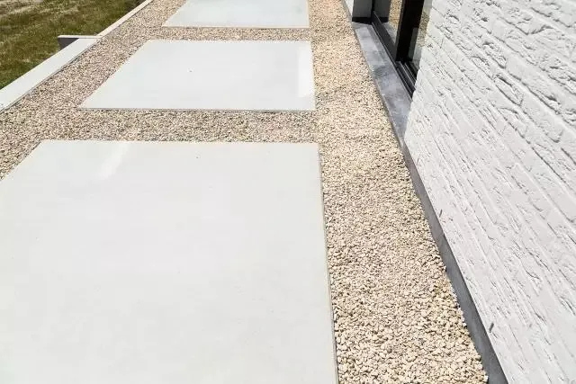 Lichte betonnen stapstenen met siergrind tussen de vlakken