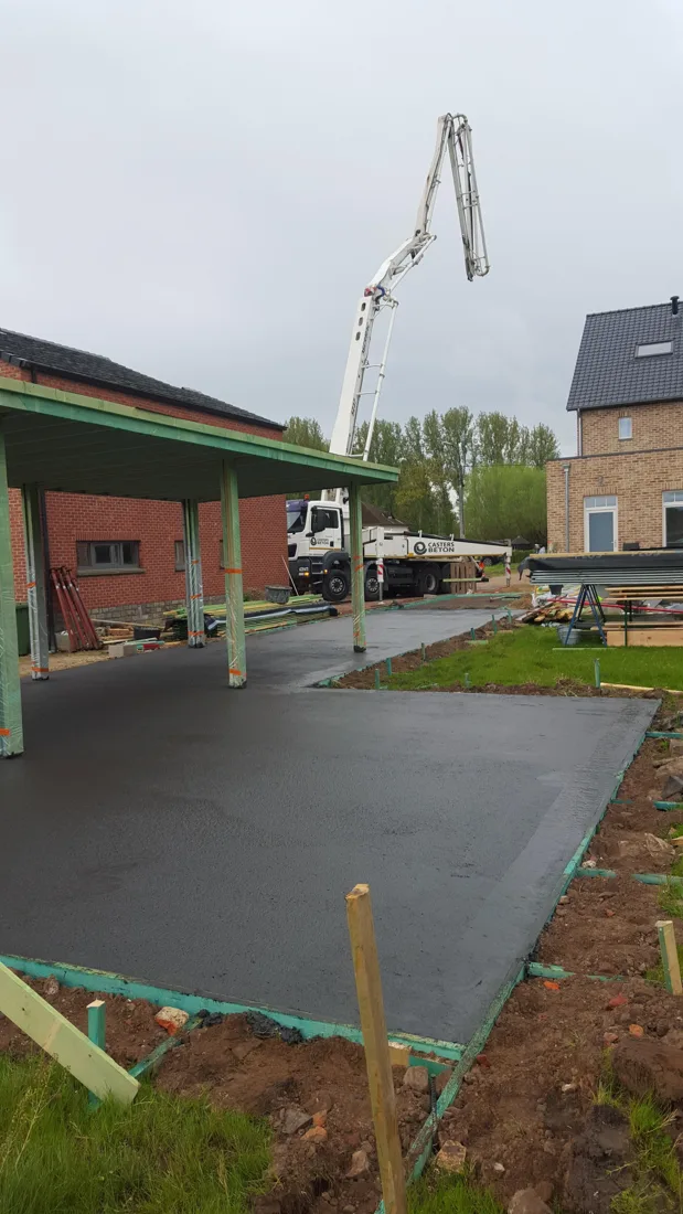 Betonpomp naast de woning tijdens de betonwerken in Stevoort