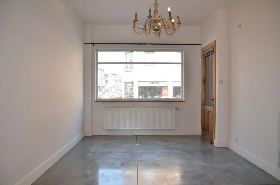 Doorzicht in de vernieuwde rijwoning met een cementkleurige betonvloer