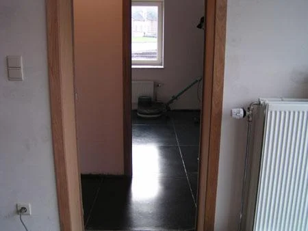 Doorgang tussen kamers met dezelfde donkere betonvloer