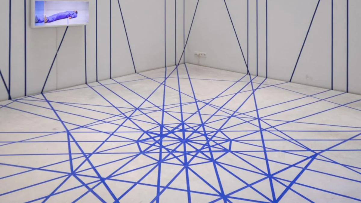 Blauwe lijnen van een installatie over de vloer bij Z33