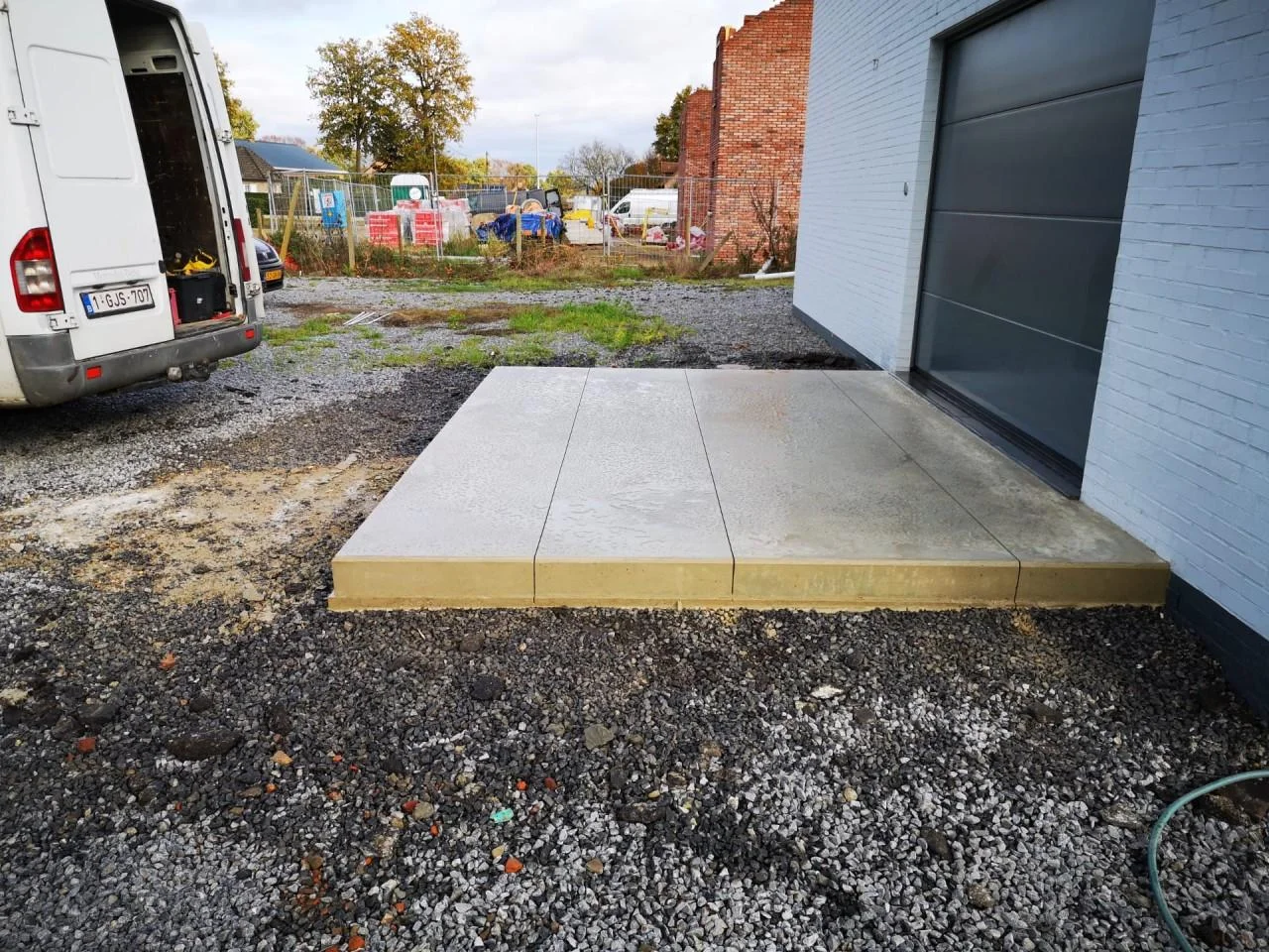 Zandkleurig betonvlak voor een garage bij een woning