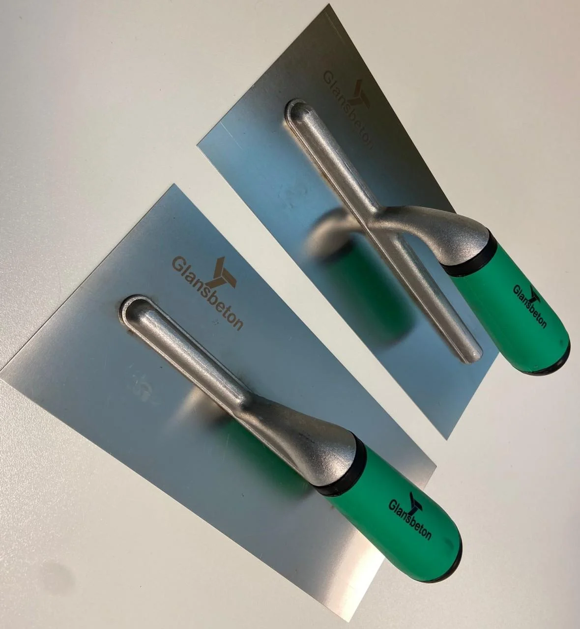 Twee Glansbeton-spanen met groene handgrepen voor handmatig kantwerk
